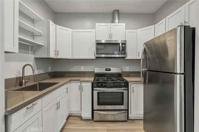 a kitchen with cabinets stainless steel appliances and a sink