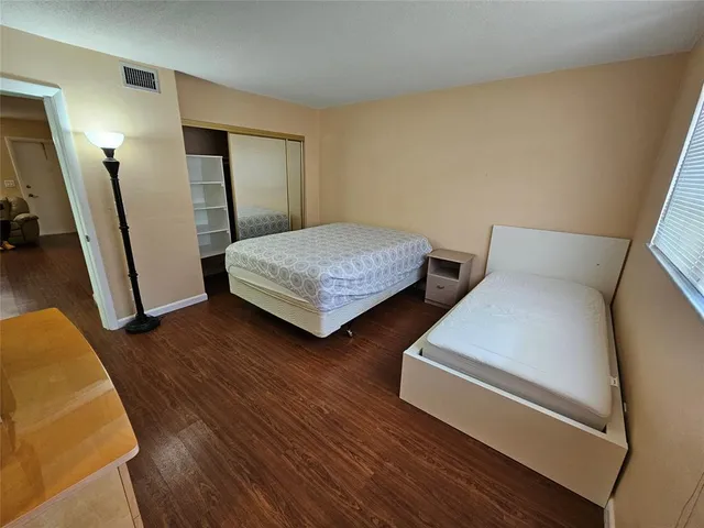 a bed sitting in a bedroom next to a window with pc on the wall