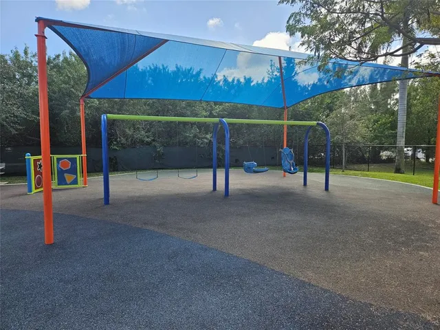 a view of a patio with chairs and tables with the shade of the tree