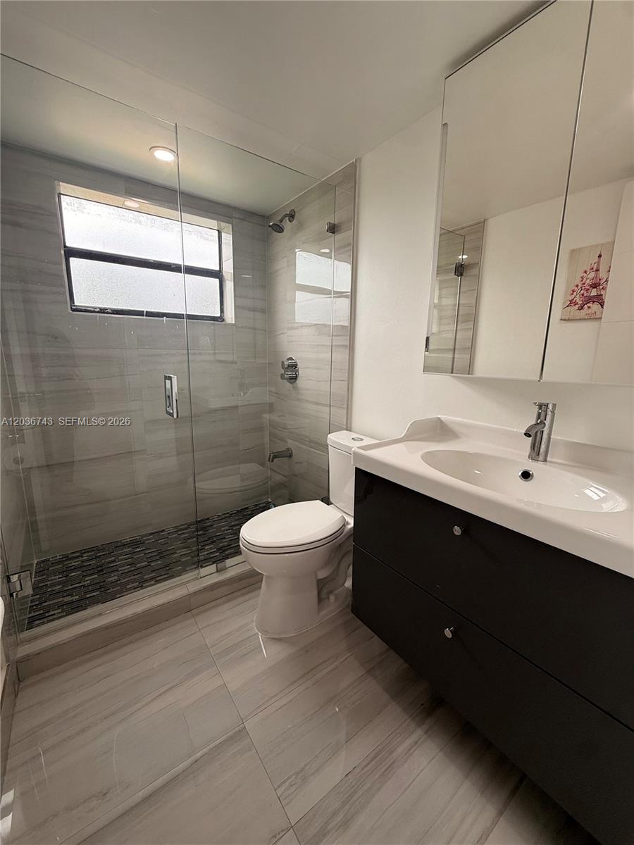 10875 Northwest 7th Street, Unit 1136 Miami, FL 33172 - Photo 16 of 25 a bathroom with a double vanity sink toilet and shower