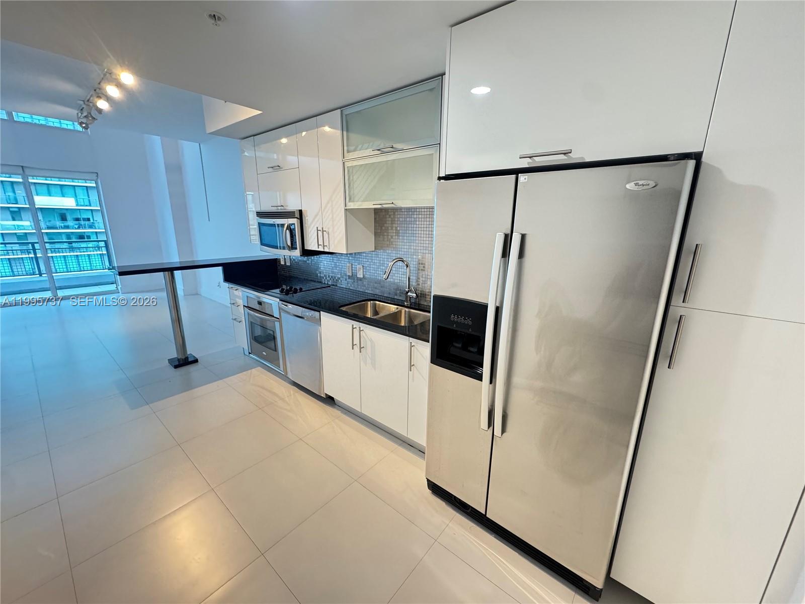 60 Southwest 13th Street, Unit 2606 Miami, FL 33130 - Photo 2 of 15 a kitchen with stainless steel appliances granite countertop a refrigerator a sink and a stove