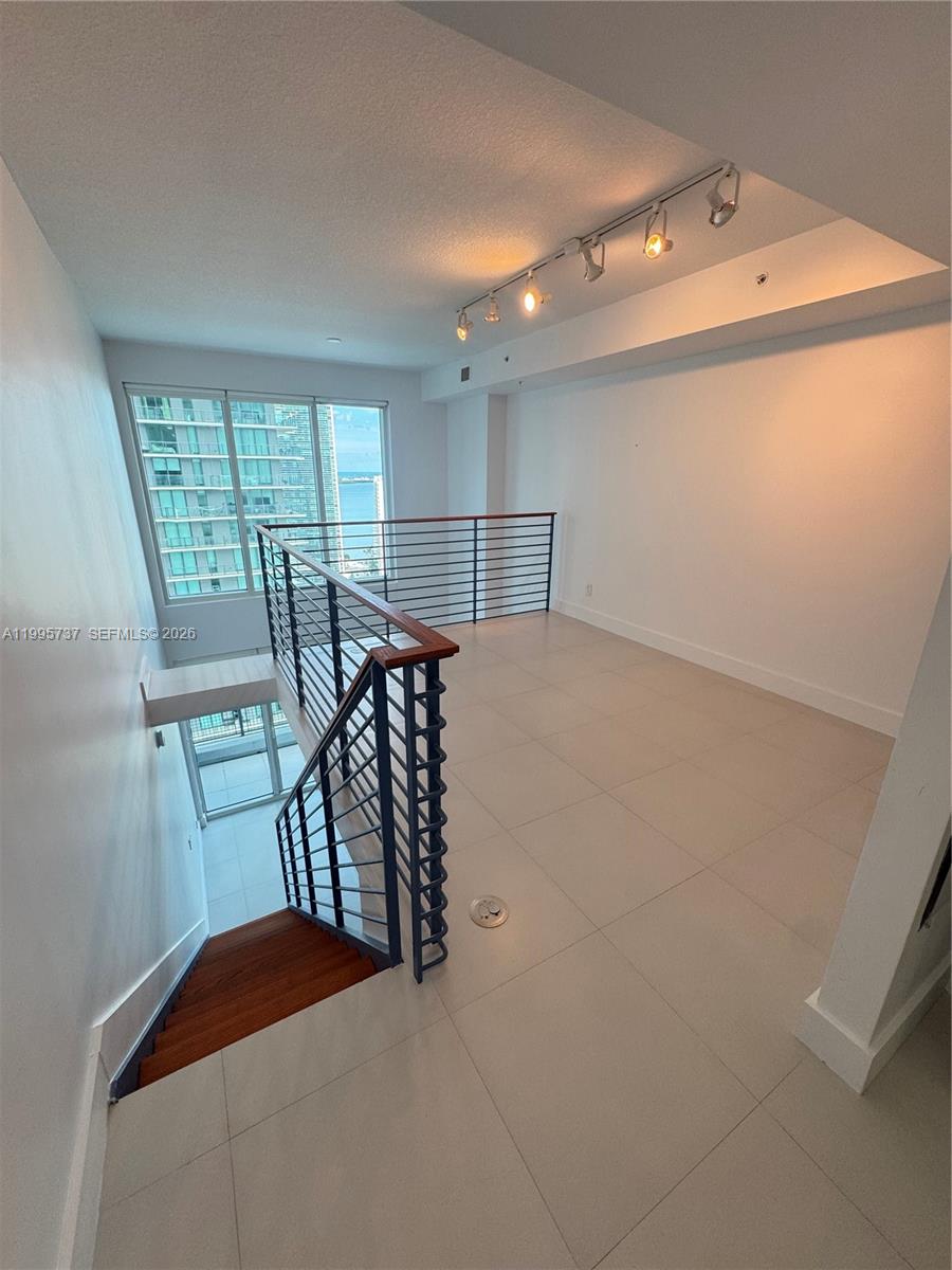 60 Southwest 13th Street, Unit 2606 Miami, FL 33130 - Photo 6 of 15 a bedroom with a bed and a table in it