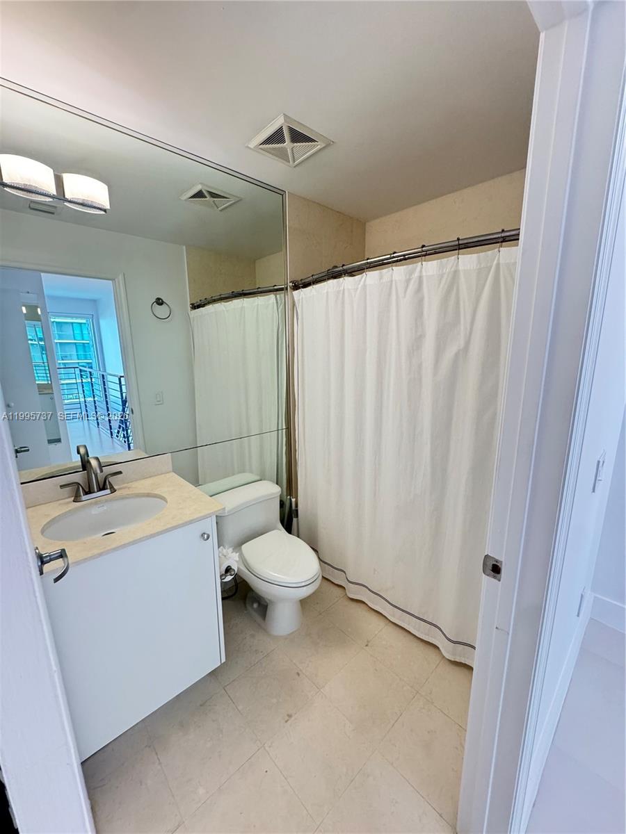 60 Southwest 13th Street, Unit 2606 Miami, FL 33130 - Photo 8 of 15 a view of a bathroom with a sink and mirror