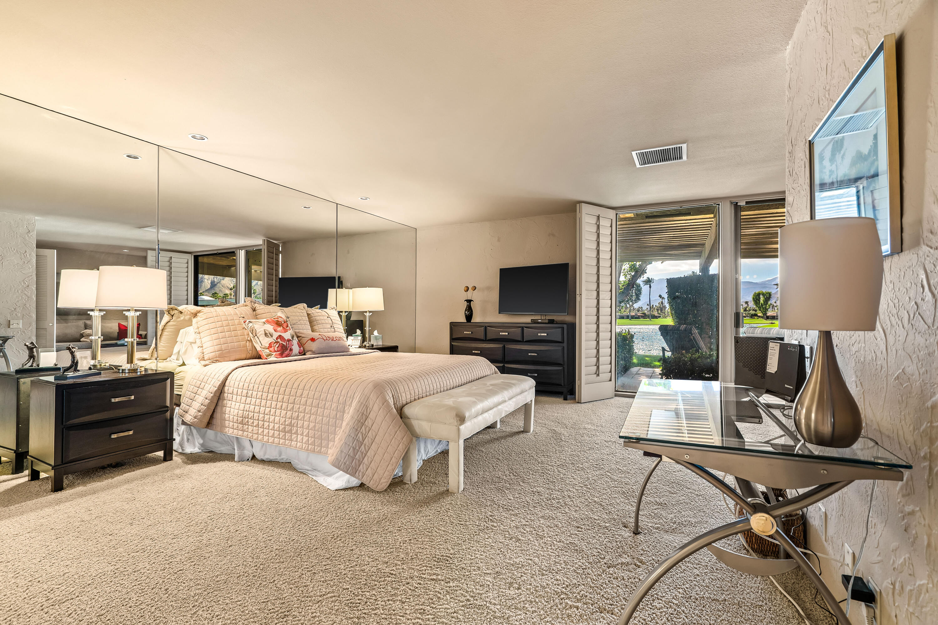 47 Columbia Drive Rancho Mirage, CA 92270 - Photo 20 of 59 a bedroom with a bed a table and flat screen tv