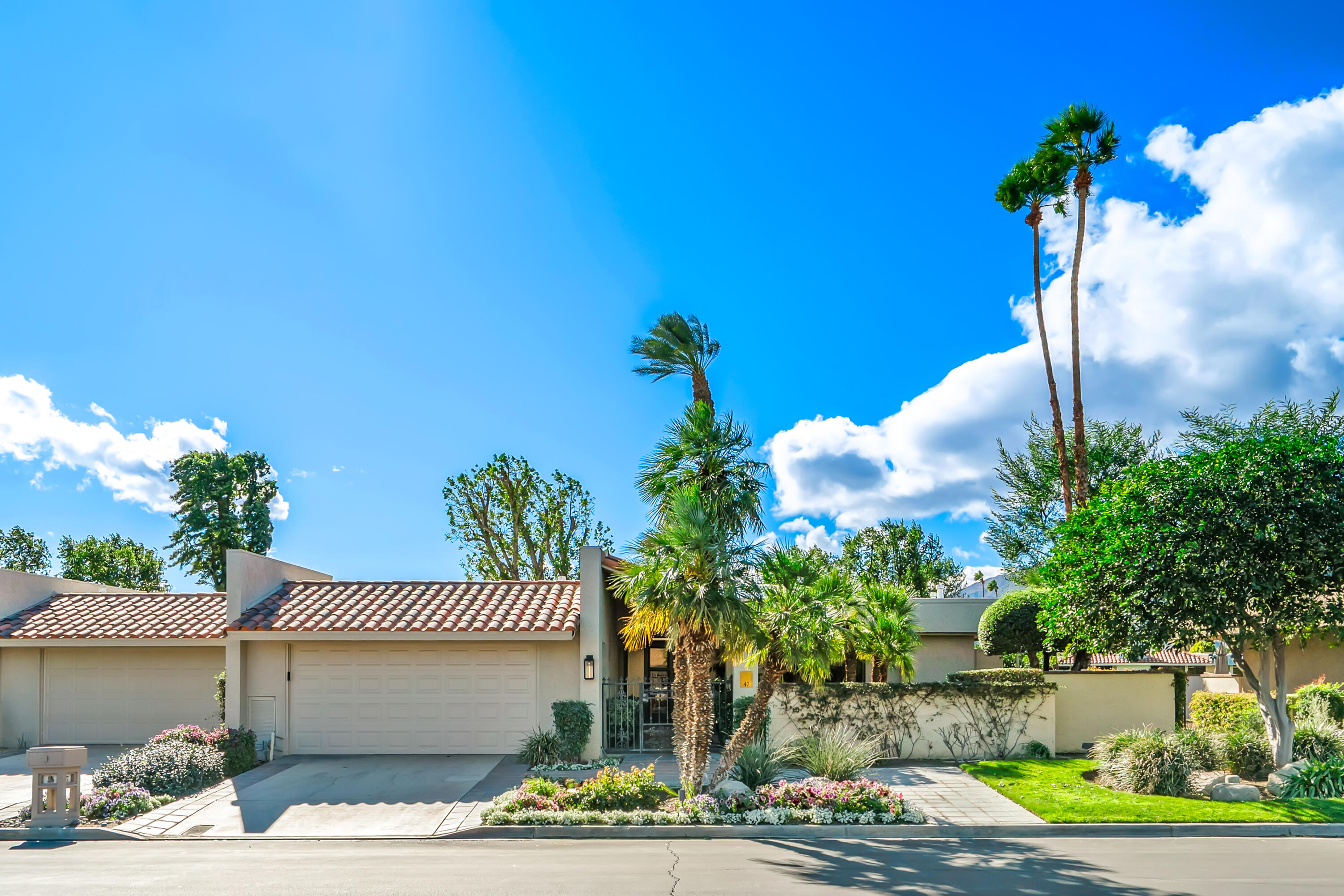 47 Columbia Drive Rancho Mirage, CA 92270 - Photo 28 of 59 a front view of a house with a yard and garage