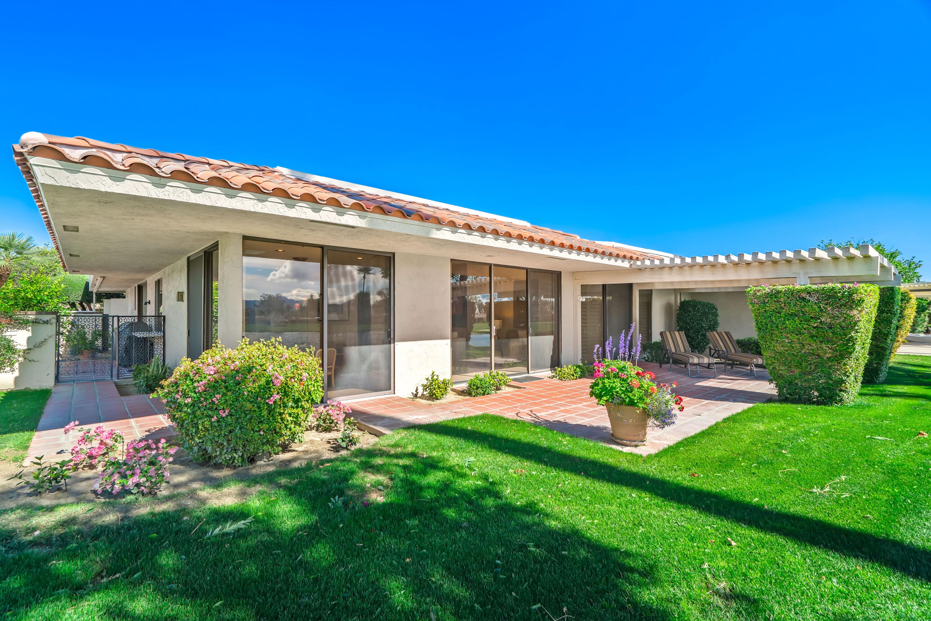47 Columbia Drive Rancho Mirage, CA 92270 - Photo 49 of 59 a front view of a house with garden and porch