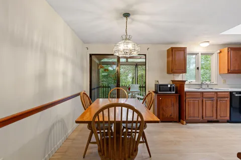a dining room with furniture a chandelier and kitchen view