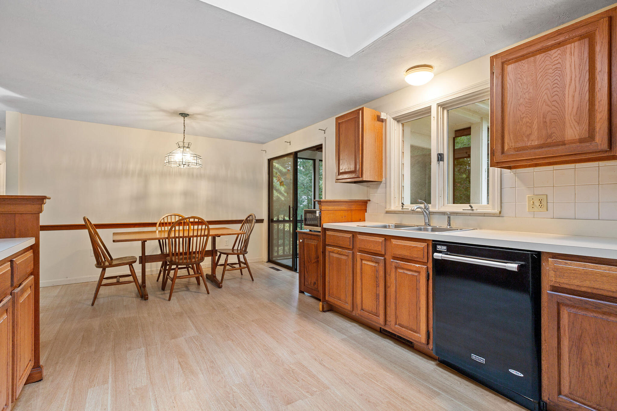 11 Windjammer Road Harwich, MA 02645 - Photo 19 of 29 a open kitchen with stainless steel appliances granite countertop a stove a refrigerator a sink dishwasher a dining table and chairs with wooden floor