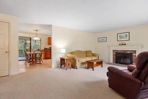 a living room with furniture a large window and a fireplace