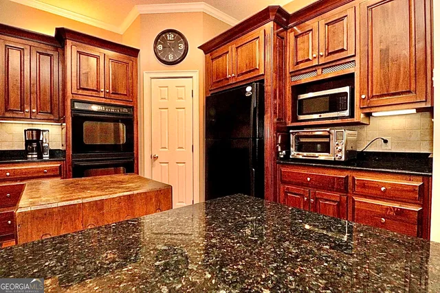 a view of a room with wooden floor staircase and a kitchen