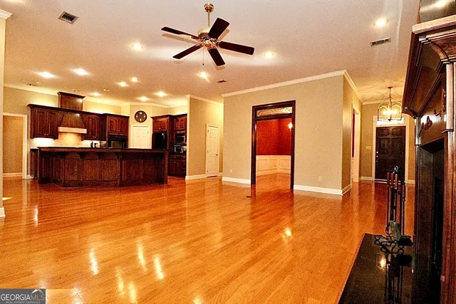 a view of a livingroom with a fireplace a ceiling fan and front door