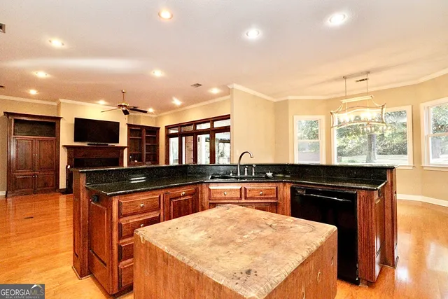 a kitchen with stainless steel appliances kitchen island granite countertop a refrigerator a stove and a sink with granite countertops