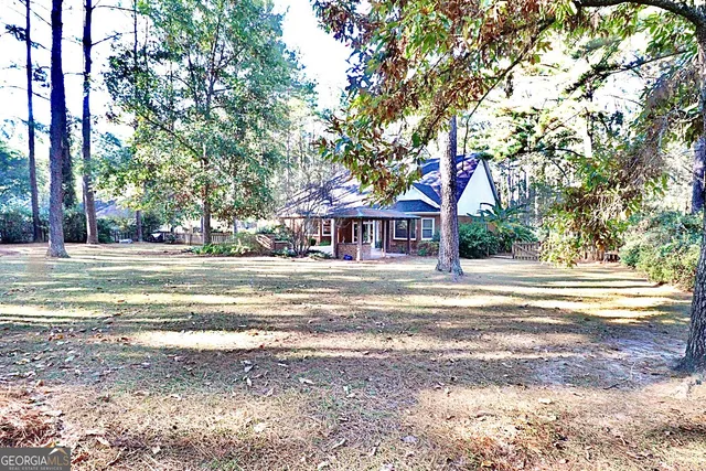 a front view of a house with a trees and a big yard