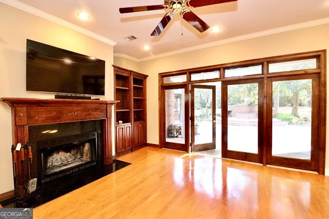 a view of an empty room and chandelier fan