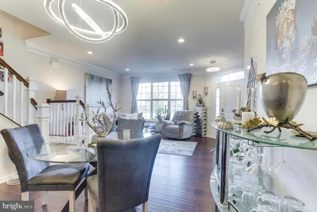 a living room with furniture a large window and wooden floor