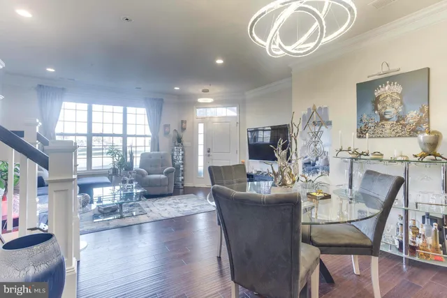 a dining room with wooden floor and large windows