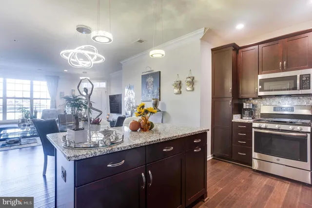 a kitchen with stainless steel appliances granite countertop a sink dishwasher stove and refrigerator with wooden floor