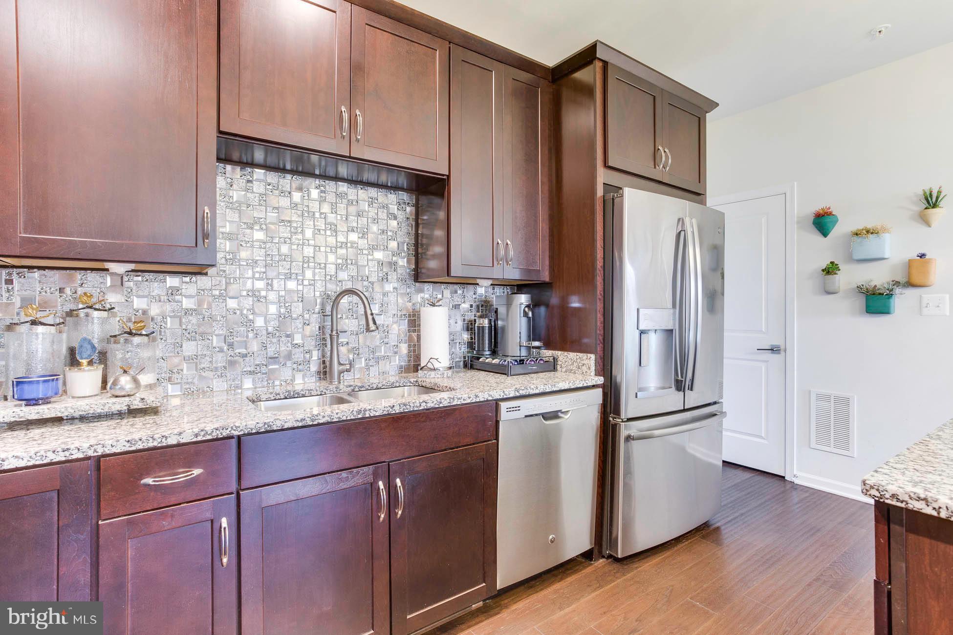43048 Vernon Ridge Terrace Ashburn, VA 20148 - Photo 22 of 40 a kitchen with a sink a refrigerator and cabinets