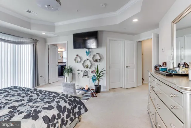 a bedroom with a bed and a flat tv screen on dresser
