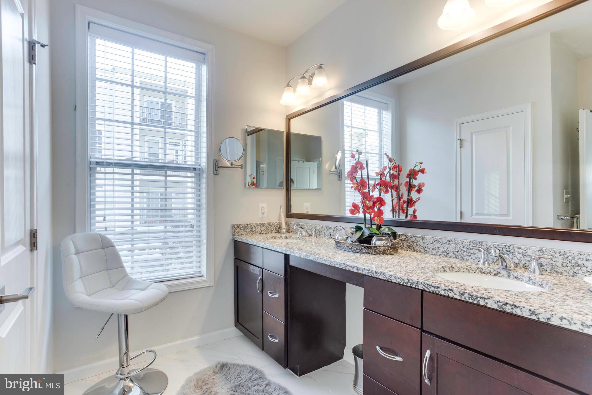 43048 Vernon Ridge Terrace Ashburn, VA 20148 - Photo 30 of 40 a bathroom with a granite countertop sink and a mirror
