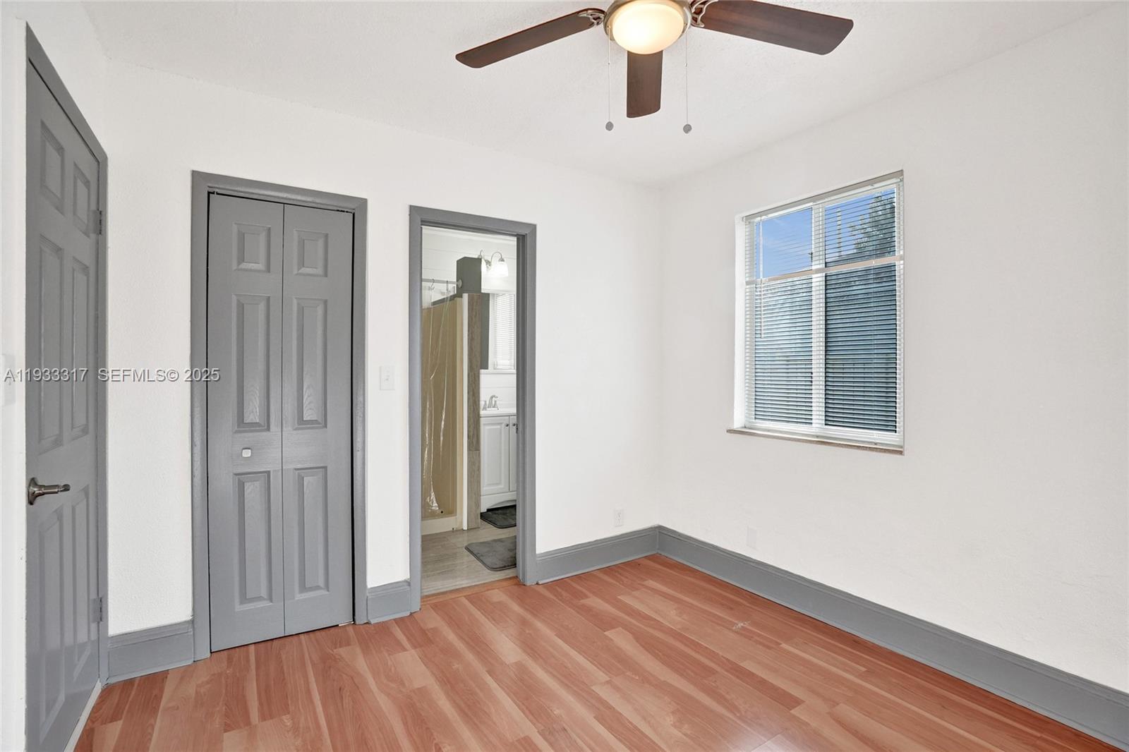 249 Southwest 4th Street, Unit 1 Dania Beach, FL 33004 - Photo 13 of 40 an empty room with a hardwood and ceiling fan