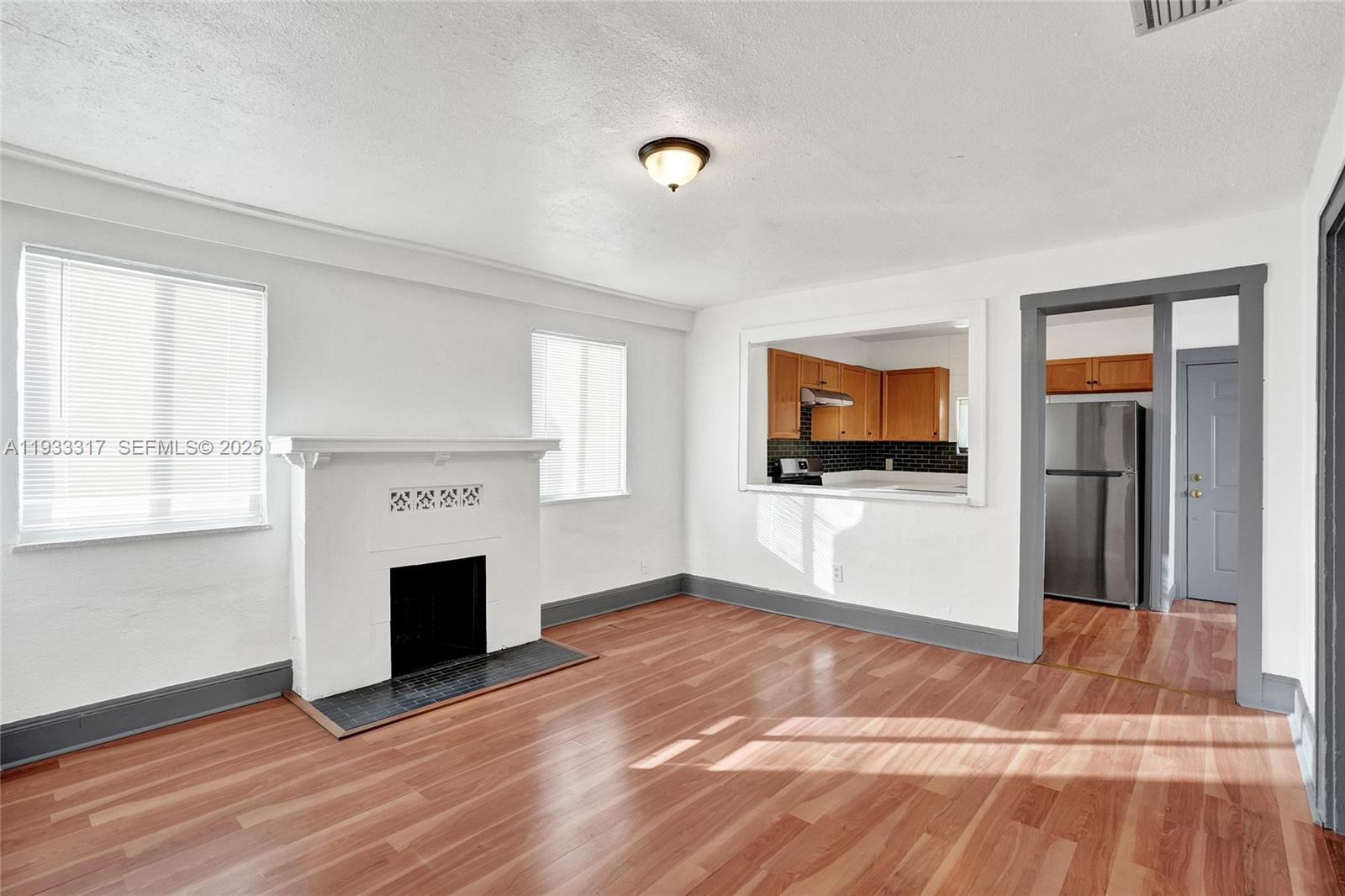 249 Southwest 4th Street, Unit 1 Dania Beach, FL 33004 - Photo 17 of 40 a view of empty room with a fireplace and windows