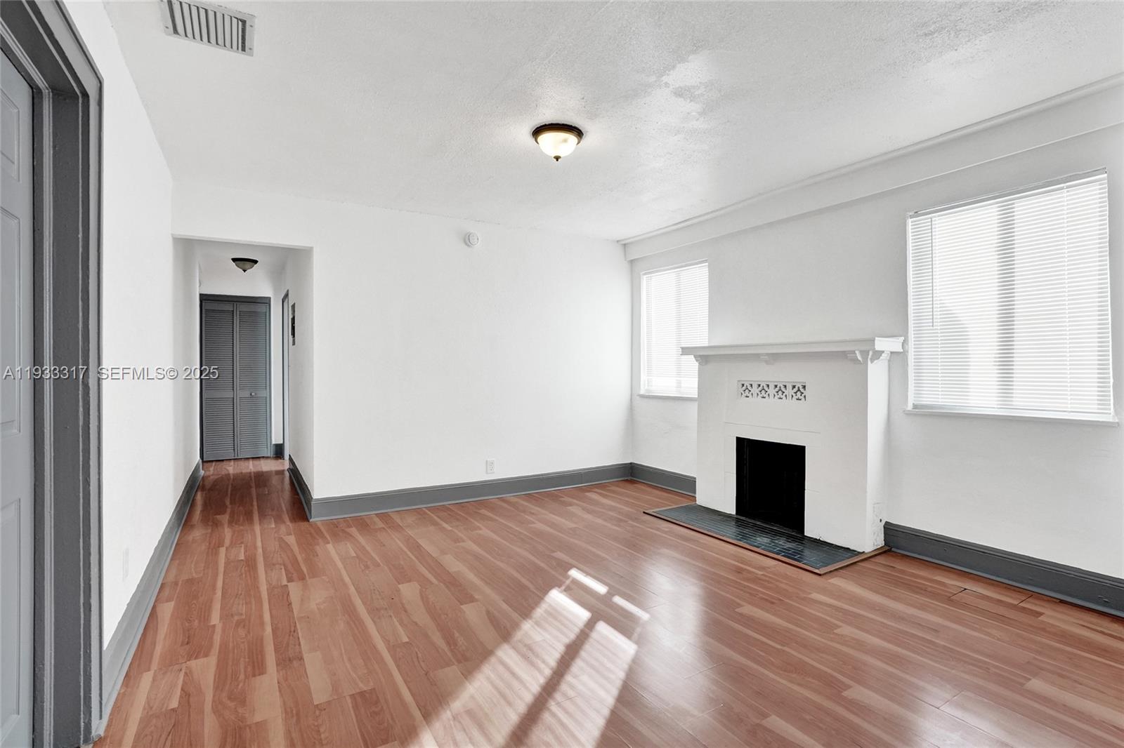 249 Southwest 4th Street, Unit 1 Dania Beach, FL 33004 - Photo 19 of 40 a view of empty room with wooden floor and fireplace