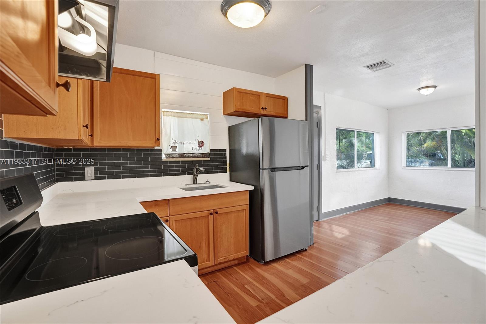 249 Southwest 4th Street, Unit 1 Dania Beach, FL 33004 - Photo 21 of 40 a kitchen with stainless steel appliances granite countertop a refrigerator and a sink