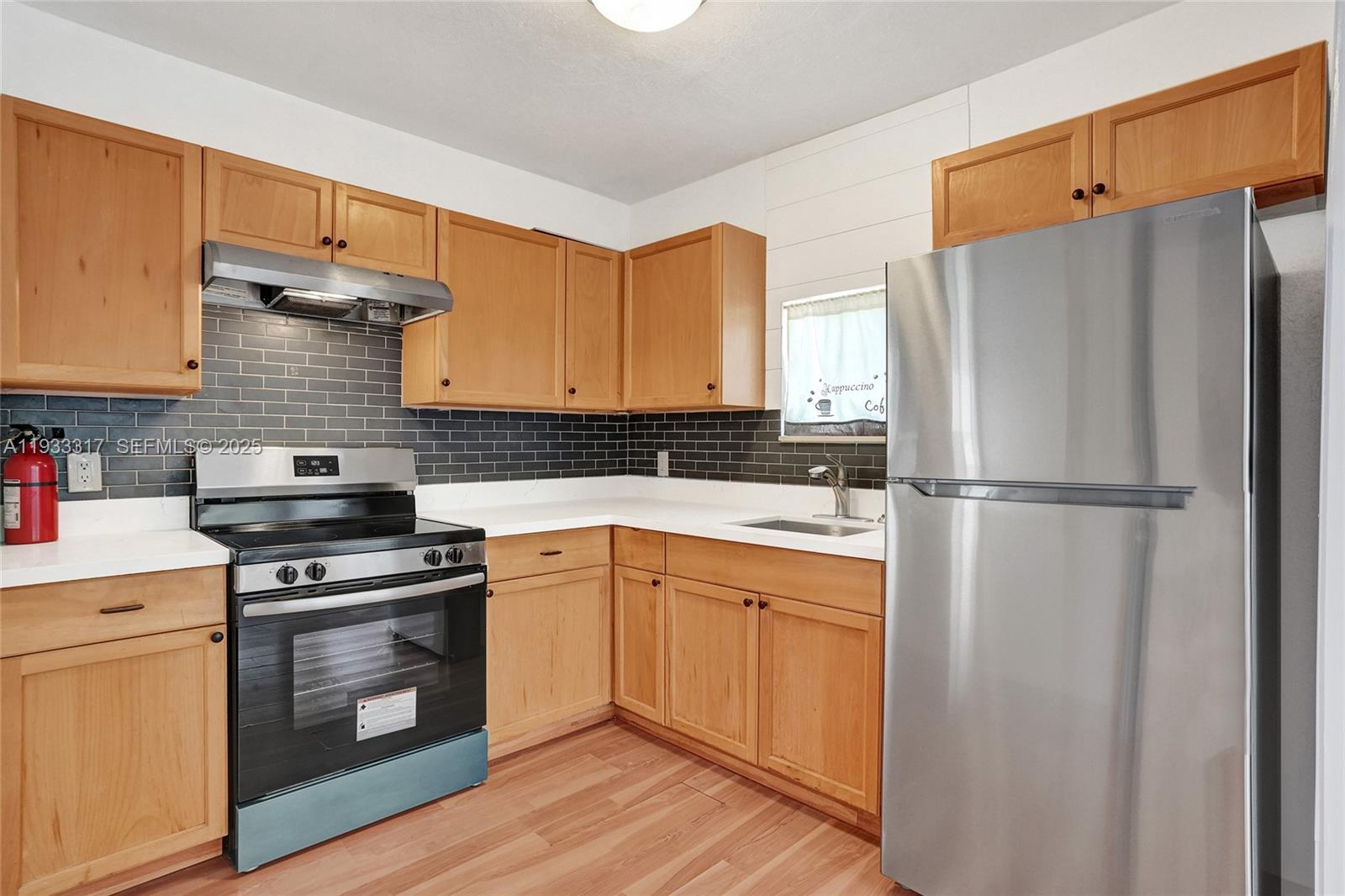 249 Southwest 4th Street, Unit 1 Dania Beach, FL 33004 - Photo 22 of 40 a kitchen with a refrigerator stove and sink