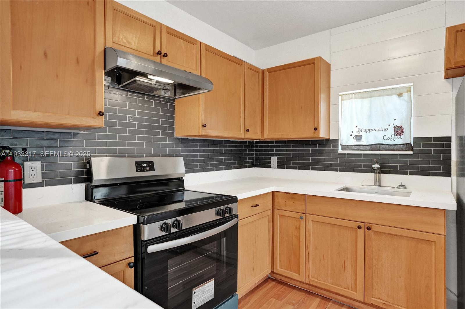 249 Southwest 4th Street, Unit 1 Dania Beach, FL 33004 - Photo 3 of 40 a kitchen with a sink stove and cabinets