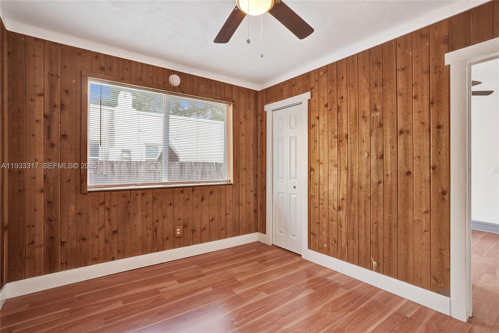 249 Southwest 4th Street, Unit 1 Dania Beach, FL 33004 - Photo 9 of 40 a view of an empty room with wooden floor and a window