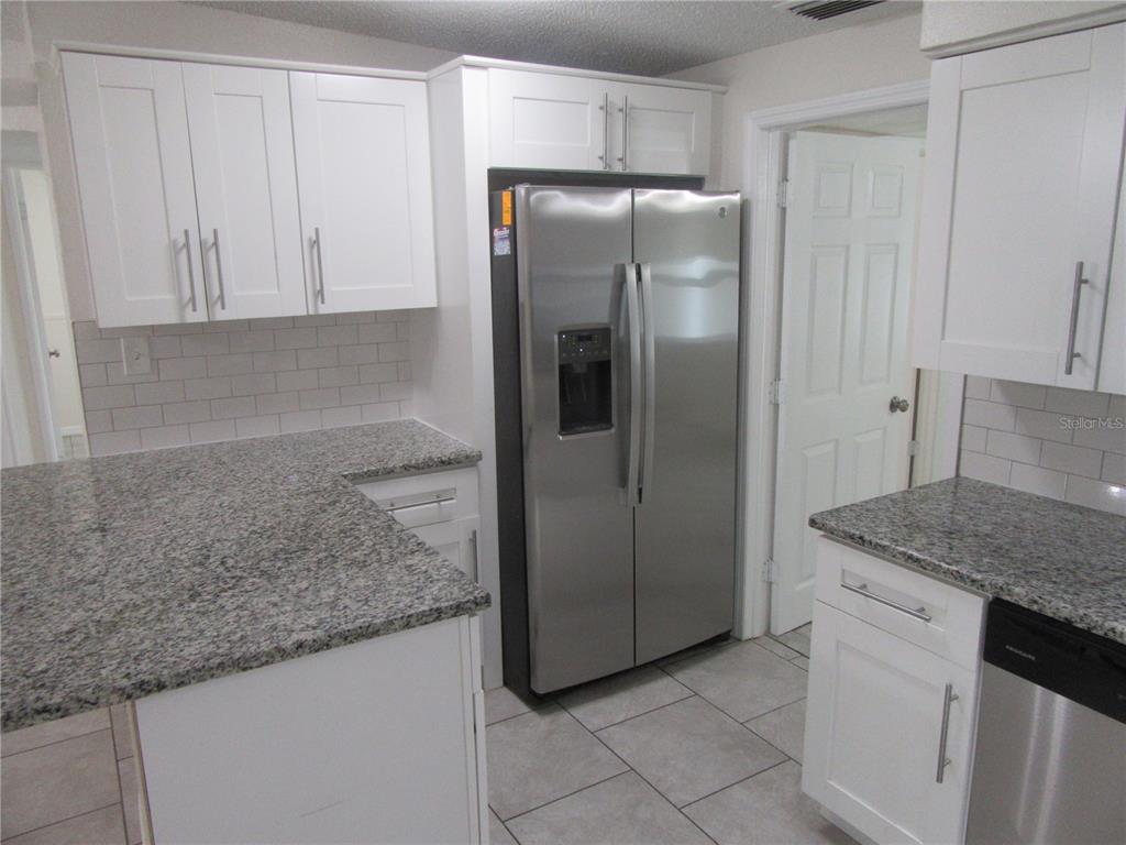 11913 104th Street Largo, FL 33773 - Photo 12 of 34 a kitchen with stainless steel appliances granite countertop a refrigerator and a sink