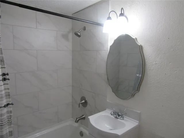 a bathroom with a sink a shower and a mirror