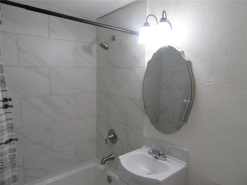 11913 104th Street Largo, FL 33773 - Photo 27 of 34 a bathroom with a sink a shower and a mirror