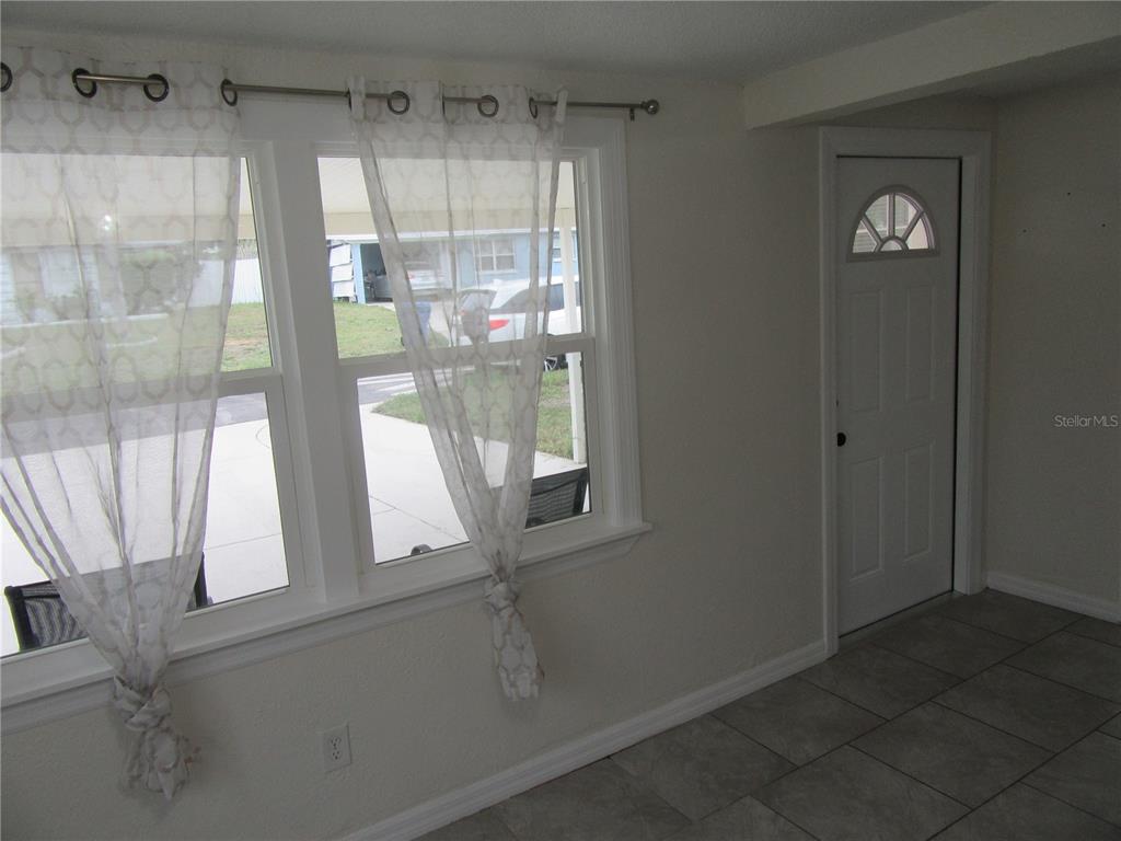 11913 104th Street Largo, FL 33773 - Photo 4 of 34 a view of empty room with wooden floor and fan