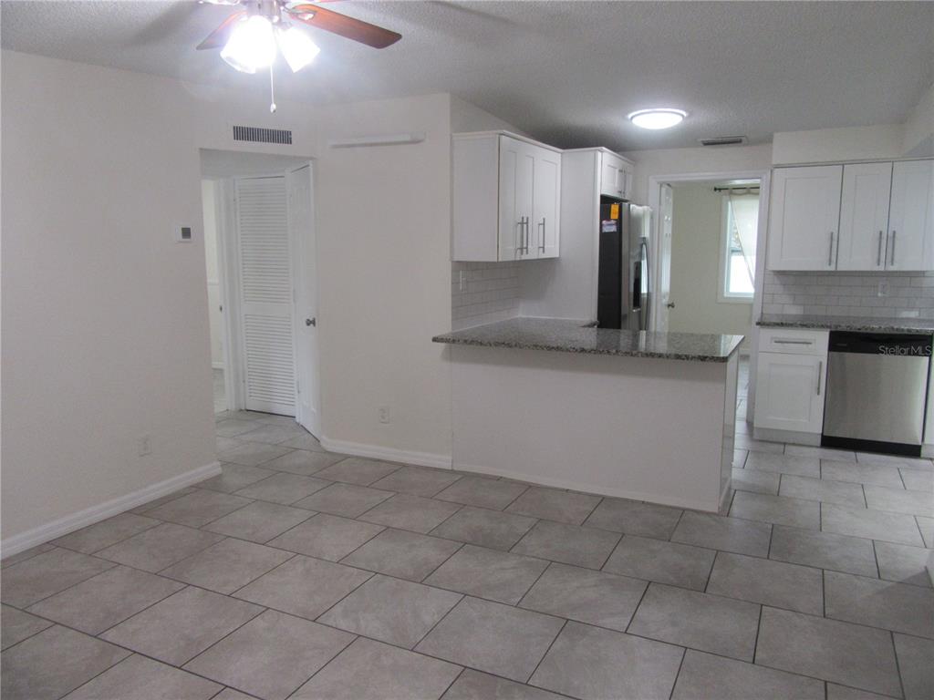 11913 104th Street Largo, FL 33773 - Photo 7 of 34 a kitchen with granite countertop a stove a sink and a refrigerator