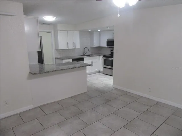 a kitchen with stainless steel appliances granite countertop a sink and a stove