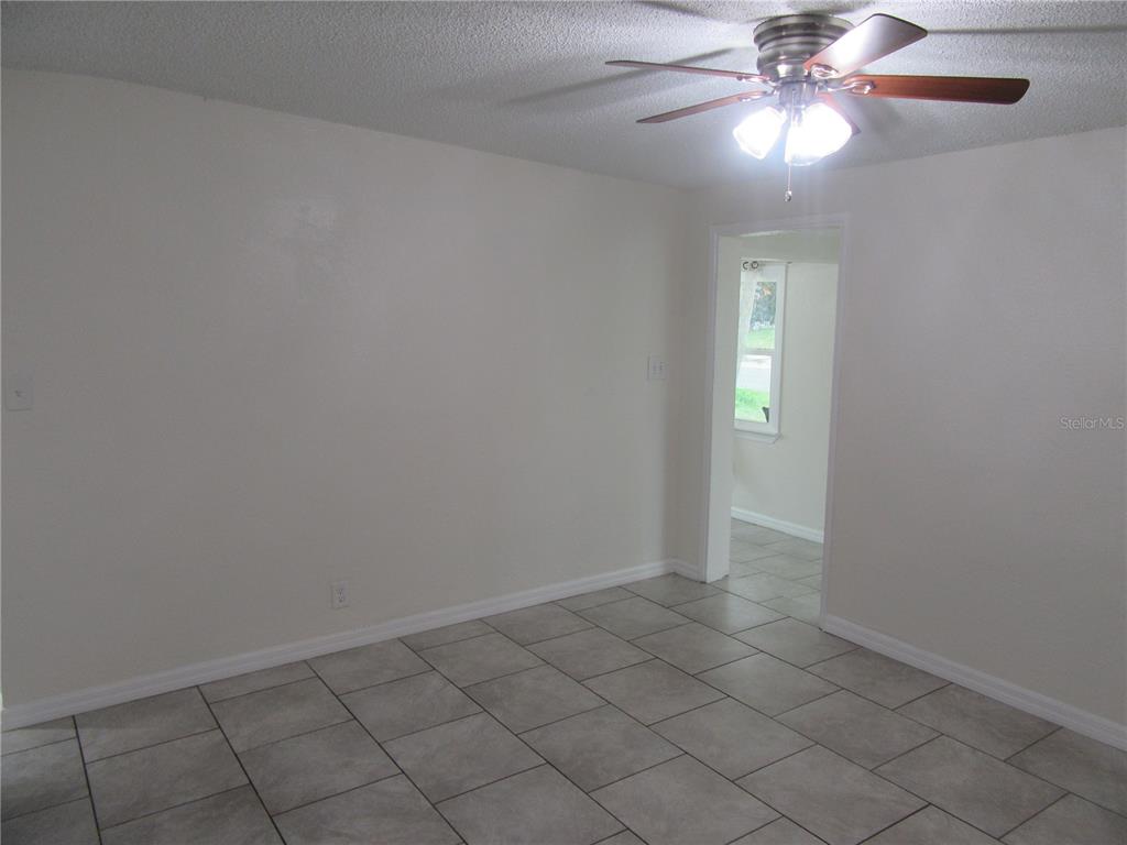 11913 104th Street Largo, FL 33773 - Photo 9 of 34 an empty room with windows and fan