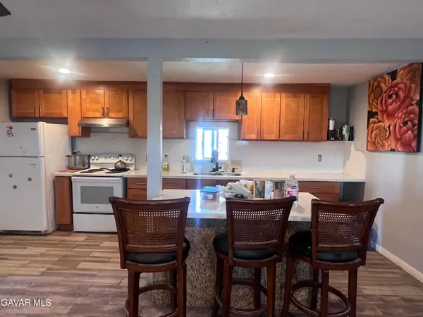 a kitchen with stainless steel appliances granite countertop a sink a stove a refrigerator cabinets and a counter top space