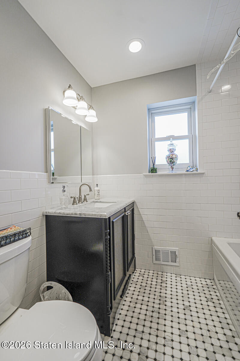 76 Berry Avenue Staten Island, NY 10312 - Photo 16 of 42 a bathroom with a sink toilet and mirror