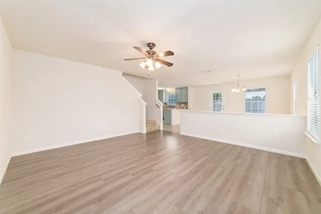 a view of a kitchen with wooden floor and a ceiling fan