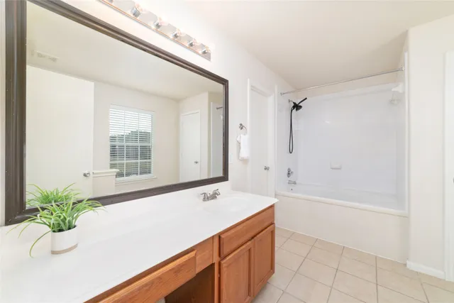 a bathroom with a tub sink and mirror