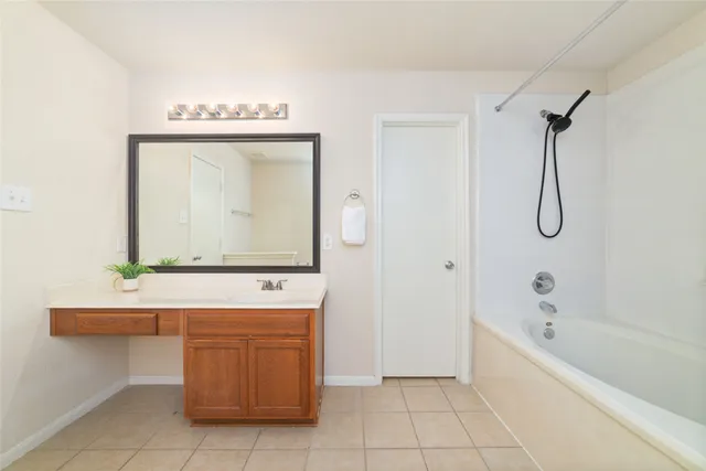 a bathroom with a bathtub sink and mirror