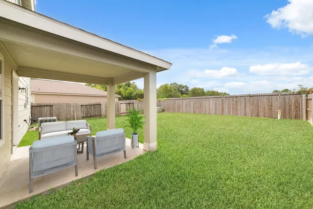 a view of backyard with seating area and green space
