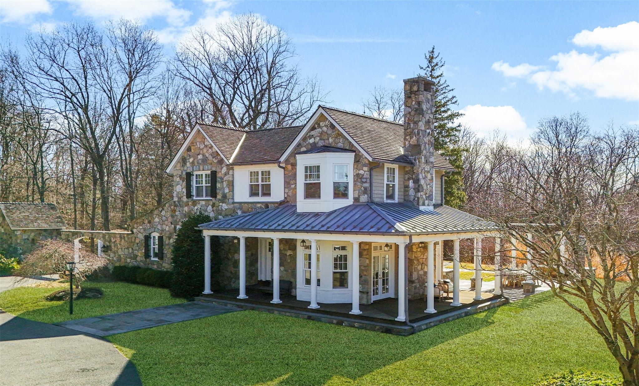 2 Quarter Mile Road Armonk, NY 10504 - Photo 1 of 1 View of front facade featuring french doors, stone siding, a chimney, and a front lawn