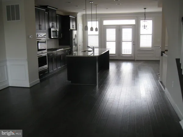 a kitchen with stainless steel appliances wooden floors and sink