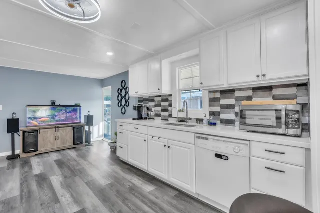 a kitchen with granite countertop a sink cabinets and wooden floor