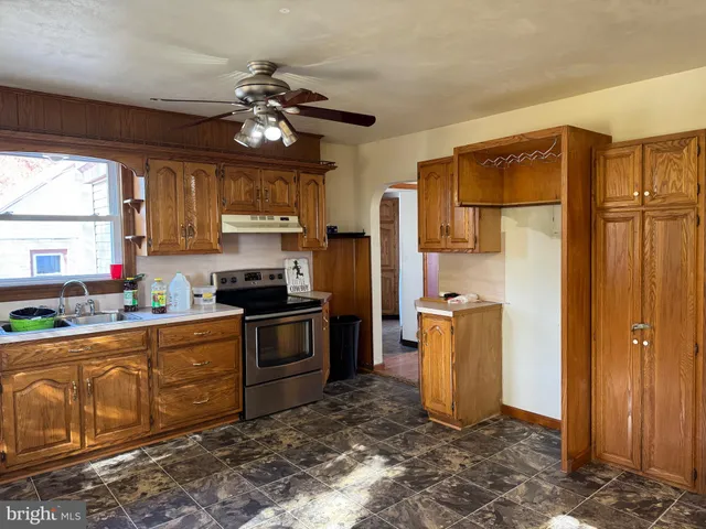 a kitchen with a refrigerator and a stove top oven
