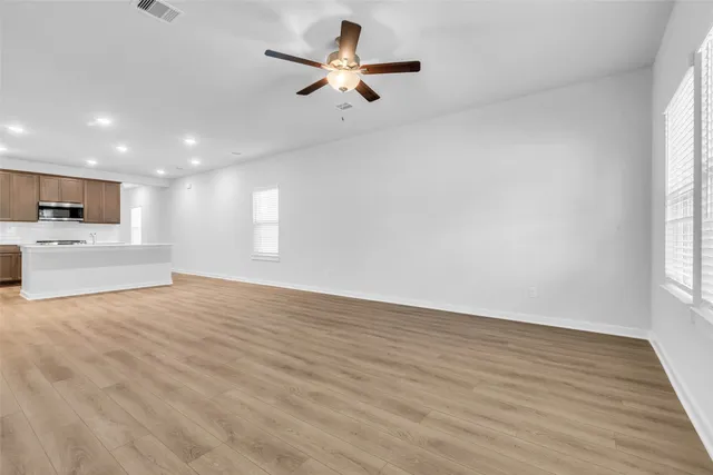 a view of empty room with kitchen and window