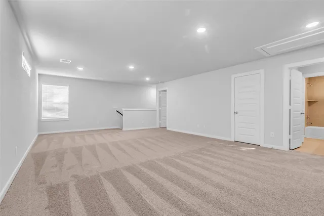 a view of empty room with windows and cabinet